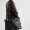 Δερμάτινη τσάντα Prada με αγκράφα και ζώνη με καρφιά Δερμάτινη τσάντα Prada με αγκράφα και ζώνη με καρφιά