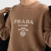 Πουλόβερ με λαιμόκοψη και λογότυπο Prada από κασμίρ και μαλλί Πουλόβερ με λαιμόκοψη και λογότυπο Prada από κασμίρ και μαλλί
